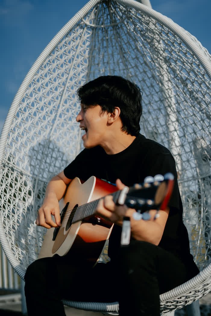 Pemain gitar Lesley santai di kursi gantung